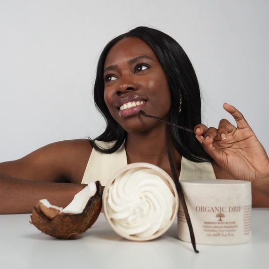 Woman holding Organic Drip Whipped Body Butter Vanilla & Coconut with fresh coconut and vanilla beans.